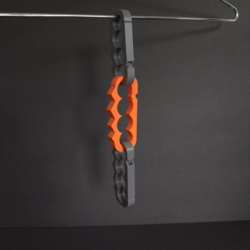 Orange and grey TactiClutch units clipped into each other, hanging as a chain from a closet rail