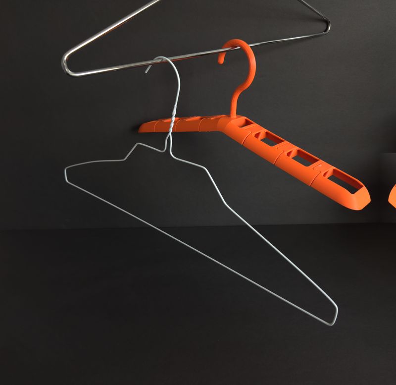 TactiHang hanging on a closet rail beside two standard wire hangers for comparison
